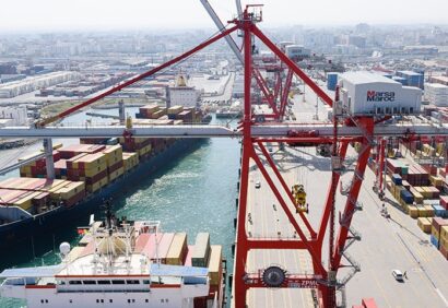 Vue aérienne d’un port chargé de conteneurs et de navires de fret à quai.