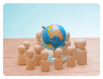 Figurines en bois entourant un globe terrestre, symbolisant les connexions internationales et la logistique mondiale.